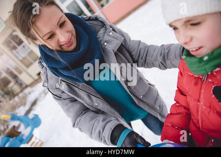 Mutter und Tochter auf Schnee überdachten Spielplatz Spaß haben Stockfoto