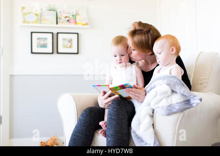 Mutter und Söhne (12-17 Monate) lesen Bilderbuch Stockfoto