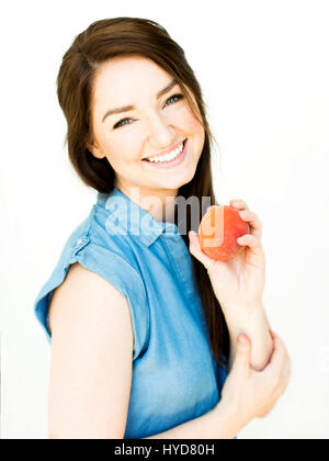 Frau trägt blaue Spitze hält Pfirsich Stockfoto