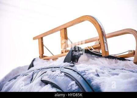 Schnee bedeckte Wagen mit Schlitten auf dem Dachgepäckträger Stockfoto