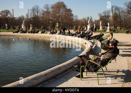 Menschen entspannen und genießen einen sonnigen Tag im Jardin des Tuileries in der Nähe von Musée du Louvre und Champs-Elysées, Paris, Frankreich Stockfoto