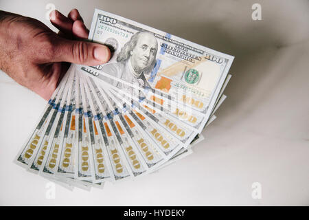 Ein Mann mit einer Hand zu Lüfter aus einem Stapel von ganz neuen Hundert-Euro-Scheine in US-Währung Stockfoto
