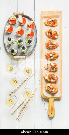 Brushettas, Gazpacho Aufnahmen, Desserts, Champagner und Strohhalme auf weißem Hintergrund Stockfoto
