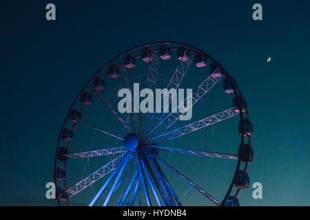 Inaktive Riesenrad vor dunklen Abendhimmel mit Halbmond Stockfoto