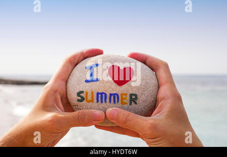 Stein mit Worten, die ich Sommer persönlich liebe Hände gegenüberliegende Meer und Himmel. Stockfoto