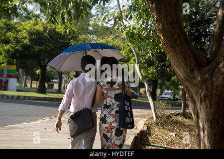 Myanmar (Burma). Yangon. Paare, die unter einem Regenschirm Stockfoto