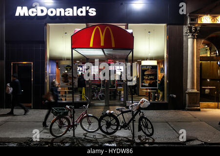 Menschen gehen von einem McDonald's Fast Food Restaurant in Manhattan. Stockfoto