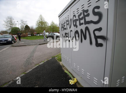 Blumen platziert neben Grafiti lesen "Flüchtlinge willkommen" in der Nähe der Szene, wo Teenager Asylbewerber Kurdisch iranische Reker Ahmed kämpft um sein Leben blieb nach einem vermuteten hasse Angriff in Croydon, Südlondon. Stockfoto