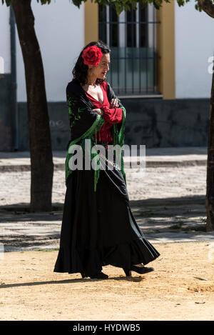 Eine spanische Frau, gekleidet wie eine Flamenco-Tänzerin warten auf eine Gruppe von Schülerinnen und Schüler geben eine Geschichtsstunde über die Ursprünge des Flamenco in Sevilla, S Stockfoto