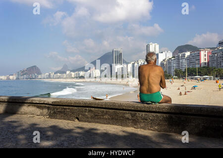 Brasilien, Rio De Janeiro: Senior woman Sitzgelegenheiten auf Leme Strand an einem sonnigen Morgen Stockfoto