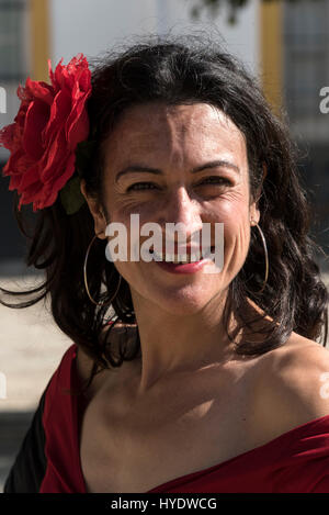 Eine spanische Frau gekleidet wie eine Flamenco-Tänzerin, eine große rote rose im Haar tragen, während der Wartezeit für eine Gruppe von Schulkindern eine Geschichte Les geben Stockfoto