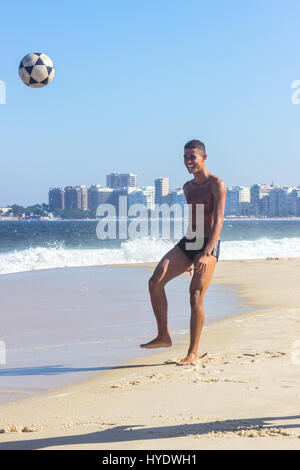 Brasilien, Rio De Janeiro: junger Mann, Fußball spielen, am Strand der Copacabana Stockfoto