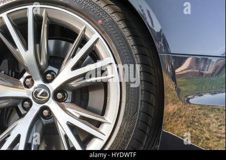 Laverstoke, Hampshire, UK - 25. August 2016: Nahaufnahme eines Luxus Lexus Automobile Rad und Reifen mit Himmel und Grünland Reflexionen im Hintergrund Stockfoto