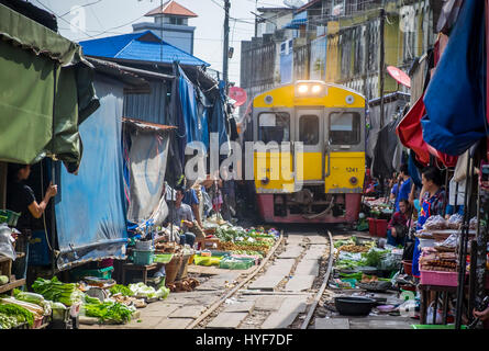 MAE KLONG - SCHMUCKWERSTÄTTEN - ca. SEPTEMBER 2014: Zug nähert sich die Stände auf dem Markt Maeklong Railway Stockfoto