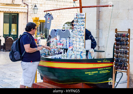 Ein Käufer inspiziert einen Souvonir Stall in Dubrovnik Stockfoto