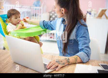 Beschäftigt Mutter Sohn füttern und so gut funktioniert Stockfoto