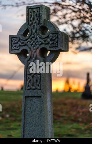 Grabstein des keltischen Kreuzes auf dem Mountain View Cemetery, Vancouver, British Columbia, Kanada, fotografiert bei Sonnenuntergang. Stockfoto