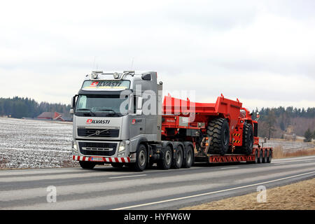 SALO, Finnland - 31. März 2017: Grau Volvo FH von Silvasti schwere transportiert ein Sandvik Muldenkipper für Bergbau an einem bewölkten Tag des Frühlings Stockfoto