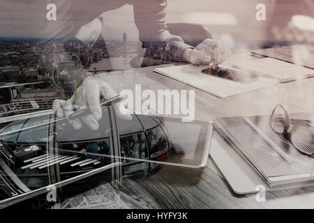 Doppelbelichtung Website Designer Holding Smartphone und funktionierende Computer digital-Tablette auf Holztisch, London Architektur buldings Stockfoto