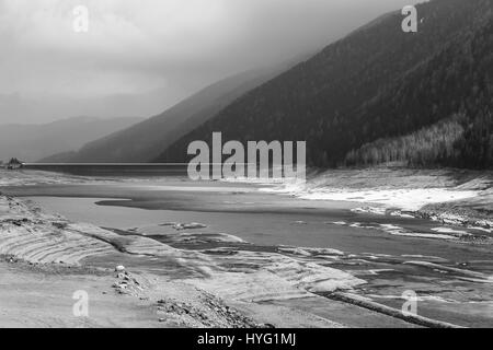 Der Stausee Lago di Zoccolo in dem Ultental in Südtirol. Der See ist Teil der Wasserkraft-Produktion im Bereich. Das Bild ist Monochrom Stockfoto