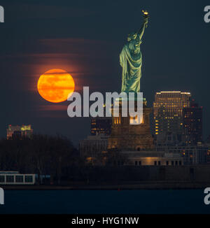 NEW YORK, USA: Gefangen zwischen dem Mond und der New Yorker Freiheitsstatue scheint ihre Fackel mit einer orange Kugel des Lichts beleuchtet zu haben. Unglaubliche Bilder zeigen Full Blutmondes erhebt sich über die legendäre grüne Dame, beleuchten die Stadt unten in orange Farbtöne.  Andere Bilder zeigen das Empire State building wird wieder durch diese spektakuläre himmlische Scheibe beleuchtet. Amerikanische Technische Redakteurin Jennifer Khordi (46) war in der Lage, diese beeindruckenden Aufnahmen von der Skyline von Jersey City und Kearny Stadt in New Jersey zu erfassen. Stockfoto