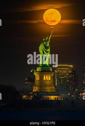 NEW YORK, USA: Gefangen zwischen dem Mond und der New Yorker Freiheitsstatue scheint ihre Fackel mit einer orange Kugel des Lichts beleuchtet zu haben. Unglaubliche Bilder zeigen Full Blutmondes erhebt sich über die legendäre grüne Dame, beleuchten die Stadt unten in orange Farbtöne.  Andere Bilder zeigen das Empire State building wird wieder durch diese spektakuläre himmlische Scheibe beleuchtet. Amerikanische Technische Redakteurin Jennifer Khordi (46) war in der Lage, diese beeindruckenden Aufnahmen von der Skyline von Jersey City und Kearny Stadt in New Jersey zu erfassen. Stockfoto