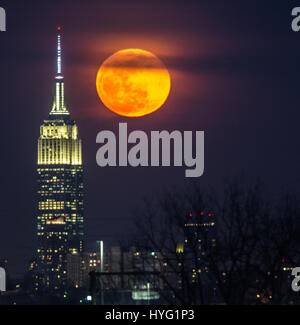 NEW YORK, USA: New Yorks legendären Empire State Building. GEFANGEN zwischen dem Mond und der New Yorker Freiheitsstatue scheint ihre Fackel mit einer orange Kugel des Lichts beleuchtet zu haben. Unglaubliche Bilder zeigen Full Blutmondes erhebt sich über die legendäre grüne Dame, beleuchten die Stadt unten in orange Farbtöne.  Andere Bilder zeigen das Empire State building wird wieder durch diese spektakuläre himmlische Scheibe beleuchtet. Amerikanische Technische Redakteurin Jennifer Khordi (46) war in der Lage, diese beeindruckenden Aufnahmen von der Skyline von Jersey City und Kearny Stadt in New Jersey zu erfassen. Stockfoto