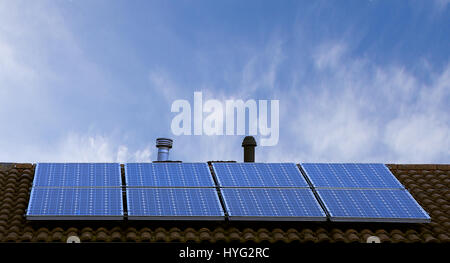 Sonnenkollektoren auf schrägen Dach mit blauen Himmel im Hintergrund, Stoke-on-Trent, Staffordshire, Großbritannien. Erneuerbare Energie, Solarzellen auf haus dach. Stockfoto