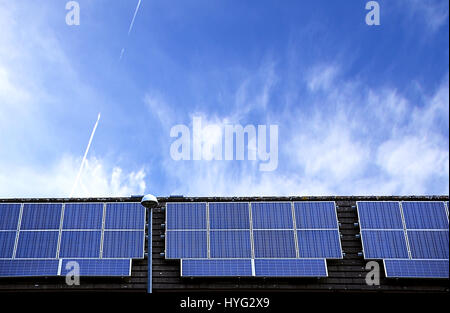 Sonnenkollektoren auf Haus Dach mit blauen Himmel im Hintergrund. Erneuerbare Energiequelle, Stoke-on-Trent, Staffordshire, Großbritannien. Solarzellen gutes Wetter. Stockfoto