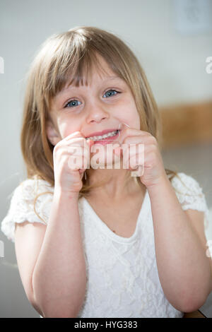 Ein kleines Mädchen im Bad ihre Zähne Zahnseide. Stockfoto