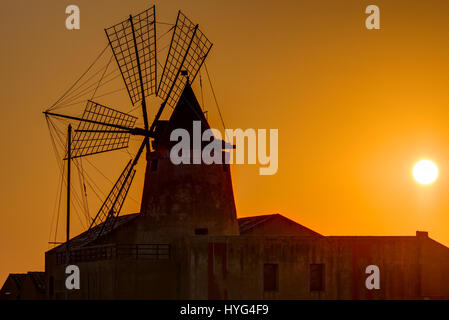 Windmühle bei Sonnenuntergang an die Salinen von Marsala auf Sizilien Stockfoto