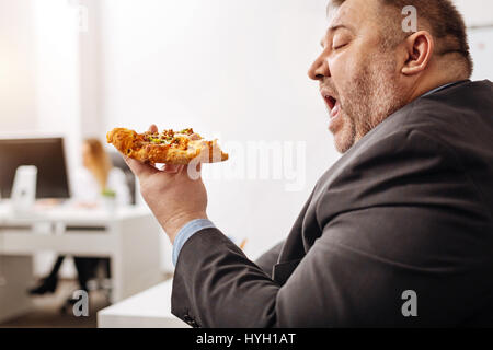 Ungesunde Büroangestellter genießen Essen Junk food Stockfoto