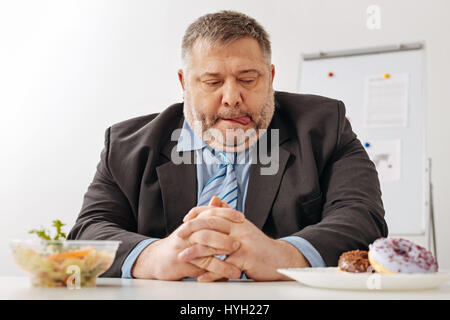 Lustige unschlüssig Arbeiter Versuchung zu widerstehen Stockfoto