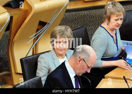 Schottlands erster Minister Nicola Sturgeon (L) hört auf Opposition Fragen auf einer schottischen Regierungserklärung in der Smith-Commission on mehr Befugnisse für Schottland, von John Swinney (C), stellvertretende erste Minister und ein SNP-Vertreter in die Kommission geliefert Stockfoto