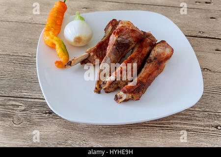 gegrillte Rippchen mit Bohnen und Krautsalat auf einem weißen Teller gegrillt. Stockfoto