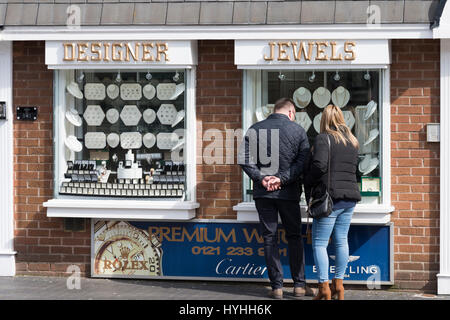 Mann und Frau stehen und blickte durch das Schaufenster an Ringen, Halsketten, Armbänder und Designerschmuck. Stockfoto