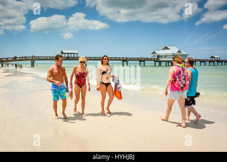 Paare, Familien, Freunde, Spaziergang am weißen Sandstrand von Clearwater Beach, FL entlang der Küste mit Pier 60 im Hintergrund aktive Outdoor-Leben Stockfoto