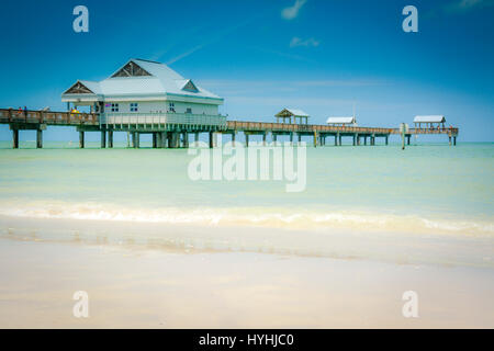 Wunderschönes türkisfarbenes Wasser in der Nähe der Küste mit Stelzenpier 60 im Hintergrund am Golf von Mexiko am Clearwater Beach, FL, USA Stockfoto