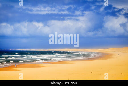 Wellen des Pazifischen Ozeans Rollen onshore von Stockton Beach in der Nähe von Anna Bay in New South Wales, Australien. Gehen Sie sonnigen Sommermorgen mit schönen blauen Himmel über Stockfoto