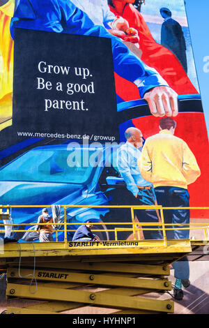 Riesige Wandgemälde Mercedes Benz Werbung in Mitte Berlin. Werbeslogan, sein Grow, ein guter Vater. Kommerzielle Künstler auf Scissor Aufzug Malerei Anzeige Stockfoto