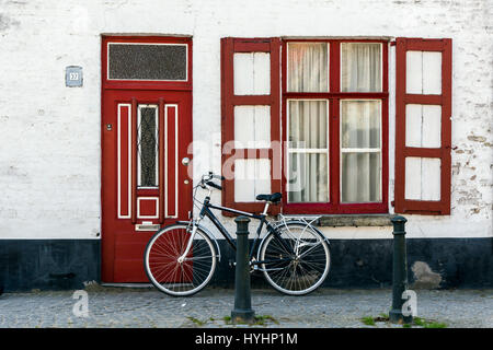 Motorrad Parken gegen eine Tür und ein Fenster in Damme, West-Flandern, Belgien Stockfoto