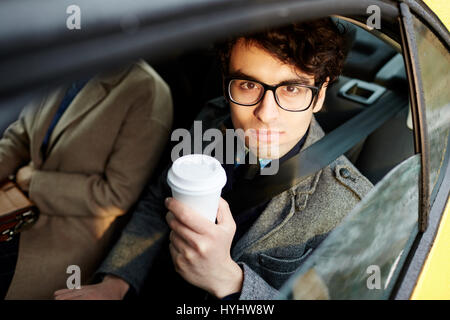 Kaufmann im Rücksitz des Autos Stockfoto
