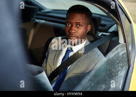 Afrikanischen Geschäftsmann lesen Zeitung im Auto Stockfoto