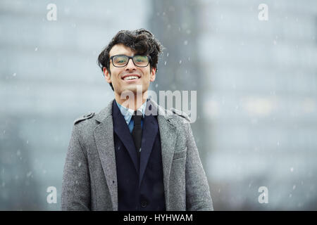 Lächelnde junge Geschäftsmann im Schnee Stockfoto