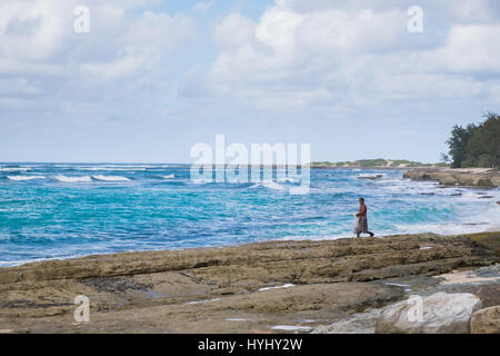 TURTLE BAY, OAHU, HAWAII - 21. Februar 2017: Net Fischer geht über Felsen in schweren Brandung am Strand in der Nähe von Turtle Bay Resort am nördlichen Ufer des Stockfoto