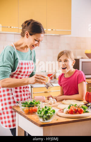 Mutter und Tochter, die Pizza in der Küche vorbereiten Stockfoto