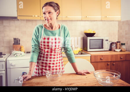 Frau stehend auf dem Tisch In der Küche mit zwei leeren Schüssel und Vorbereitung, Kochen Stockfoto