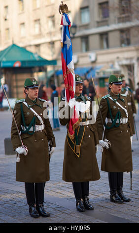 Mitglieder der Carabineros marschieren mit eine zeremonielle Flagge als Bestandteil der Wechsel der Wachablösung am La Moneda in Santiago, Chile Stockfoto