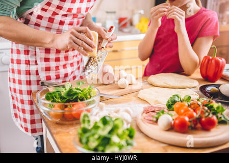 Mutter und Tochter, die Pizza in der Küche vorbereiten Stockfoto
