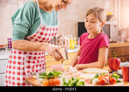 Mutter und Tochter, die Pizza in der Küche vorbereiten Stockfoto